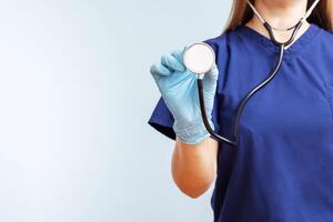 fêmea médico dentro uniforme com estetoscópio em uma azul fundo foto