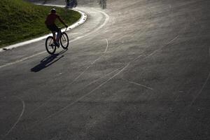 ciclista Treinamento em a ciclismo rastrear às pôr do sol. saudável estilo de vida conceito foto