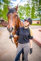 adorável jovem mulher vestindo capacete acariciando para dela Castanho cavalo foto