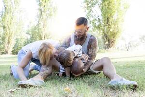 jovem casal com criança tendo Diversão às a parque com rúgbi bola foto