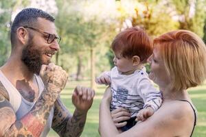 feliz família com criança tendo Diversão às a parque foto