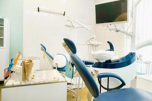 uma cadeira vazia no consultório do dentista. consultório de dentista vazio foto