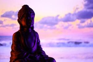 Buda purnima e vesak dia conceito, Buda estátua com baixo chave luz contra lindo e colorida fundo. meditação foto