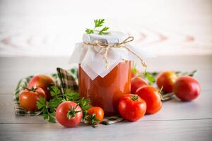 cozinhou caseiro tomate suco enlatado dentro uma jarra do natural tomates. foto