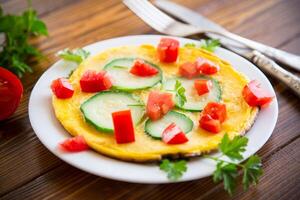 frito omelete com abobrinha, tomates, ervas dentro uma prato foto