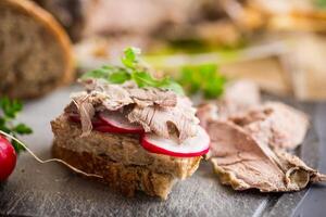 sanduíche com cozido carne, rabanete e ervas foto