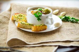 quente cozinhou sopa com Bruxelas brotos, legumes e croutons, dentro uma placa. foto