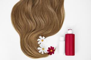 Cosmético para cabelo e flores para cabelo em uma branco fundo. saudável e lindo cabelo. cabelo Cuidado. cópia de espaço para texto foto