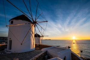 moinhos de vento gregos tradicionais na ilha de mykonos ao nascer do sol, cyclades, grécia foto