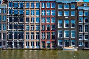 casas e barco em amsterdam canal Damrak com reflexão. ams foto