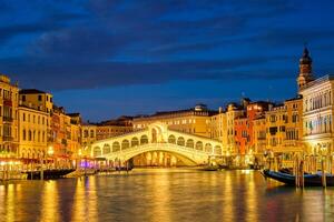 rialto ponte ponte di rialto sobre grande canal às noite dentro Veneza, Itália foto