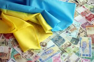 ucraniano bandeira em muitos notas do diferente moeda. fundo do guerra financiamento foto
