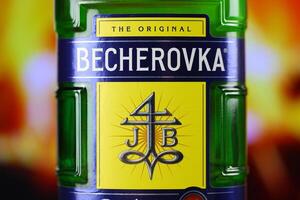 Kyiv, Ucrânia - pode 4, 2022 becherovka original álcool garrafa em de madeira mesa com vermelho lareira foto