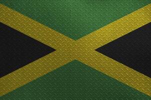 Jamaica bandeira retratado dentro pintura cores em velho escovado metal prato ou parede fechar-se. texturizado bandeira em rude fundo foto