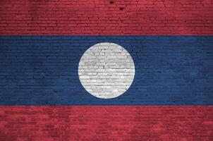 Laos bandeira retratado dentro pintura cores em velho tijolo muro. texturizado bandeira em grande tijolo parede alvenaria fundo foto