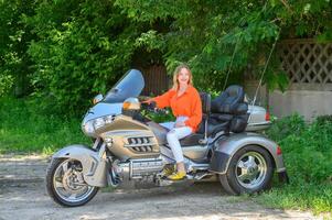 retrato do uma jovem lindo menina em uma motocicleta 3 foto