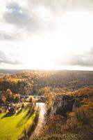 rochoso meio Ambiente perto a Cidade do dinant com uma curso de água este formulários natural meandros dentro outono cor. a pôr do sol ilumina uma colorida floresta foto