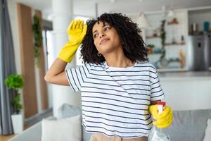 cansado e Exausta mulher, frustrado com fazendo Muito de trabalhos sobre a casa em repouso para uma minuto ou limpando dela testa depois de acabamento trabalhar. lar, serviço de limpeza conceito foto