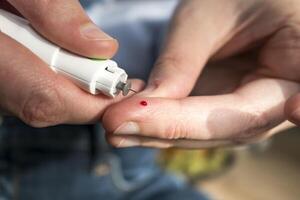 mulher picada dela dedo para Verifica sangue glicose nível com glicosímetro, teste sangue glicose para diabetes foto