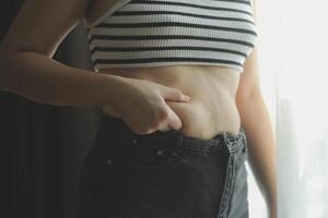 mulheres corpo gordo barriga. obeso mulher mão segurando excessivo barriga gordo. dieta estilo de vida conceito para reduzir barriga e forma acima saudável estômago músculo. foto