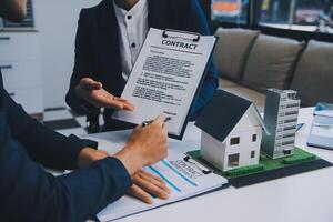 agente imobiliário falou sobre os termos do contrato de compra de casa e pediu ao cliente para assinar os documentos para fazer o contrato legalmente, venda de casa e conceito de seguro de casa. foto