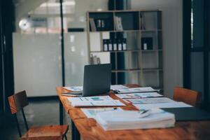 local de trabalho de escritório com laptop e telefone inteligente na mesa de madeira foto