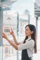 uma cafeteria proprietário monitores uma Desculpe nós estão fechadas placa com uma conteúdo sorriso, marcação a fim do uma cumprindo dia do o negócio dentro dela acolhedor estabelecimento. foto