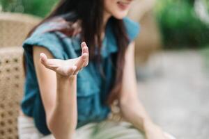 fechar acima do uma mulher mão gesticulando durante uma conversação, com uma borrado fundo enfatizando a conceito do comunicação e digital interação. foto