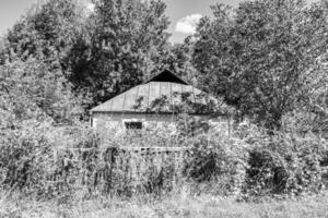 linda e velha casa de fazenda abandonada na zona rural em fundo natural foto