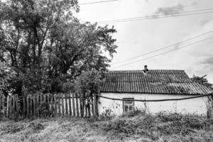 linda e velha casa de fazenda abandonada na zona rural em fundo natural foto