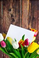 colorida tulipas ramalhete e cumprimento cartão em de madeira fundo. feriado presente. foto