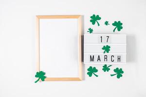 minimalista flatlay para st. patrick's dia. trevo e quadro, Armação em uma branco fundo. feliz irlandês feriado, símbolos do Boa sorte. foto