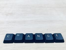 a palavra mudança escrito com computador teclado chaves em branco de madeira fundo. foto