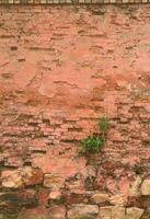muito velho estragado vermelho tijolo parede com desossado tijolos e cimento argamassa foto