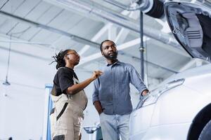 profissional dentro reparar fazer compras usando ar tecnologia para mostrar homem defeituoso carro peças. garagem trabalhador usando futurista vr fone de ouvido para informar cliente do o que perigos dele veículo é voltado para E se esquerda não reparado foto