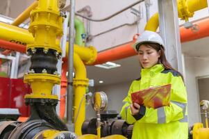 manutenção técnico às uma aquecimento planta, petroquímica trabalhadores supervisionar a Operação do gás e óleo dutos dentro a fábrica, engenheiros colocar audição protetor às quarto com muitos tubos foto