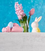 ovos, cerâmico coelhinho, Rosa jacinto em branco mesa. turquesa pano de fundo. Páscoa cartão. baixo ângulo tomada. foto