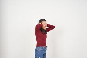 jovem ásia mulher dentro vermelho camiseta cobertura orelhas ouve incomodando ruído isolado em branco fundo foto
