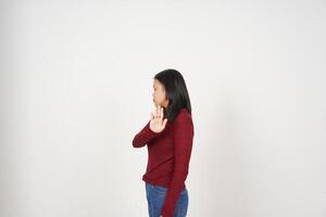 jovem ásia mulher dentro vermelho camiseta Pare mão gesto, rejeição conceito isolado em branco fundo foto