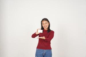 jovem ásia mulher dentro vermelho camiseta mostrando em branco cartão isolado em branco fundo foto
