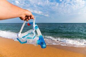 embaixo da agua mascarar para snorkeling contra a pano de fundo do pôr do sol arenoso costa e mar foto