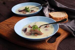 cremoso sopa com boletos cogumelo e ervas em de madeira mesa foto