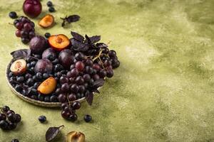 sortimento do roxa fruta ameixa, uva, mirtilo e manjericão foto