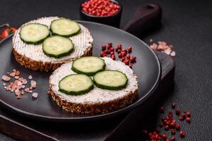 delicioso vegetariano sanduíche com grelhado brinde, creme queijo, pepinos e sementes foto