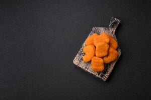 deliciosos nuggets de frango crocantes frescos em um fundo escuro de concreto foto