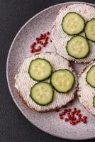 delicioso vegetariano sanduíche com grelhado brinde, creme queijo, pepinos e sementes foto