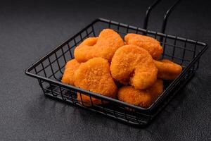 deliciosos nuggets de frango crocantes frescos em um fundo escuro de concreto foto