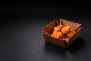 deliciosos nuggets de frango crocantes frescos em um fundo escuro de concreto foto