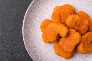 deliciosos nuggets de frango crocantes frescos em um fundo escuro de concreto foto