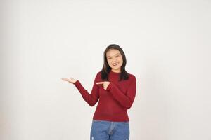 jovem ásia mulher dentro vermelho camiseta mostrando e segurando em aberto Palma cópia de espaço isolado em branco fundo foto